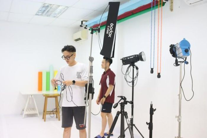 Chàng trai chuẩn bị thiết bị cho buổi quay ngắn tại studio công ty.