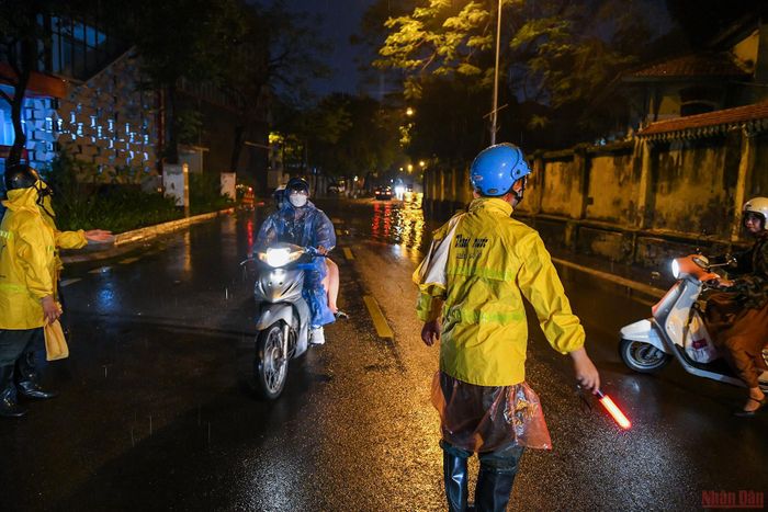 Trọng cùng các đồng nghiệp hướng dẫn người dân quay đầu tránh đi vào điểm ngập sâu.