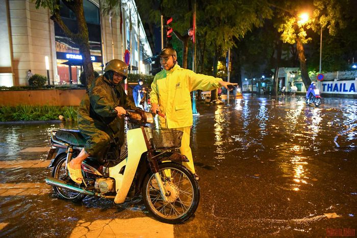 Nhân viên thoát nước Hà Nội tận tình hướng dẫn người tham gia giao thông tránh đi vào điểm ngập sâu. 