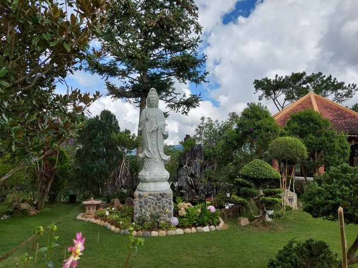 Thấp thoáng trong những khu vườn nhiều hoa lá là tượng Phật bà Quan âm.