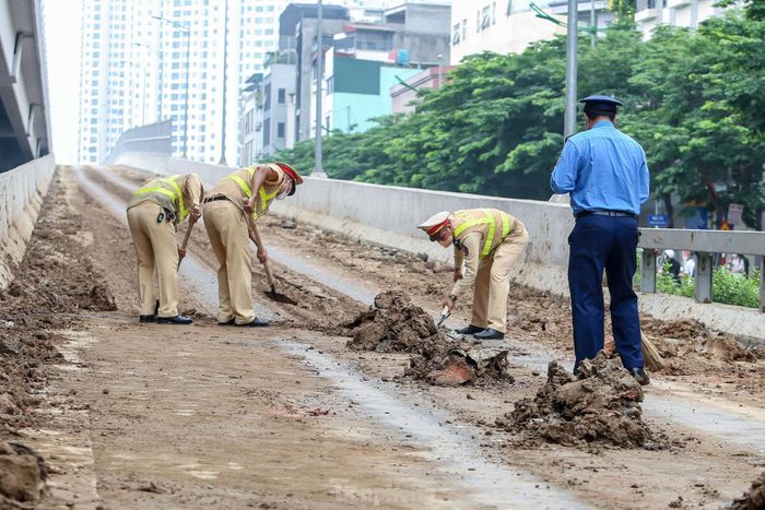 Lực lượng CSGT và Thanh tra giao thông có mặt để thu gọn đống bùn đất.