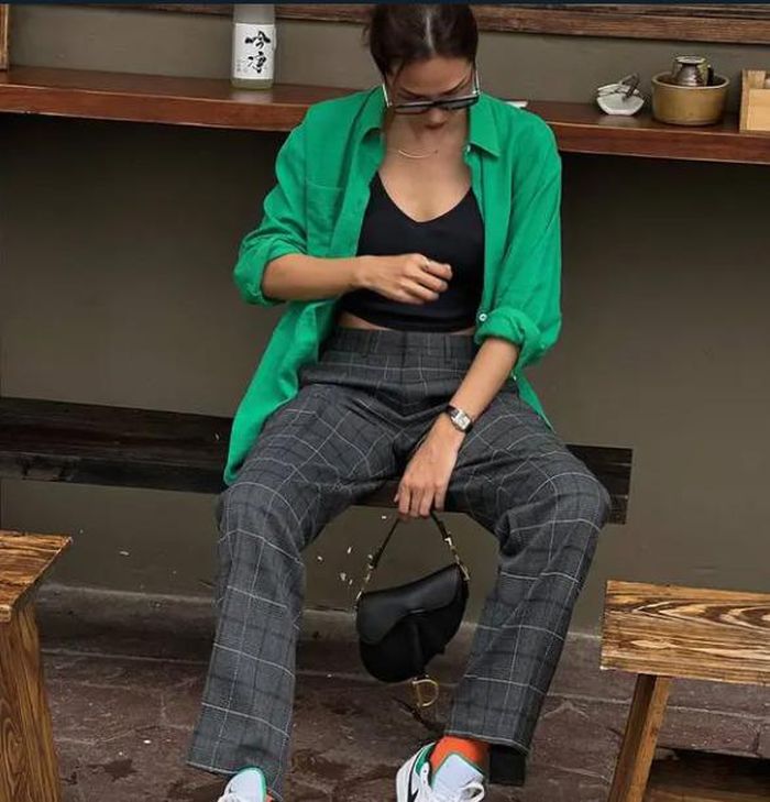  Sơ mi xanh lá đậm là item rất dễ mặc. Mẫu áo này nổi bật mà cũng trang nhã. Minh Triệu đã layer mẫu áo bên ngoài combo áo đen + quần kẻ, tạo nên outfit rất chất chơi. 