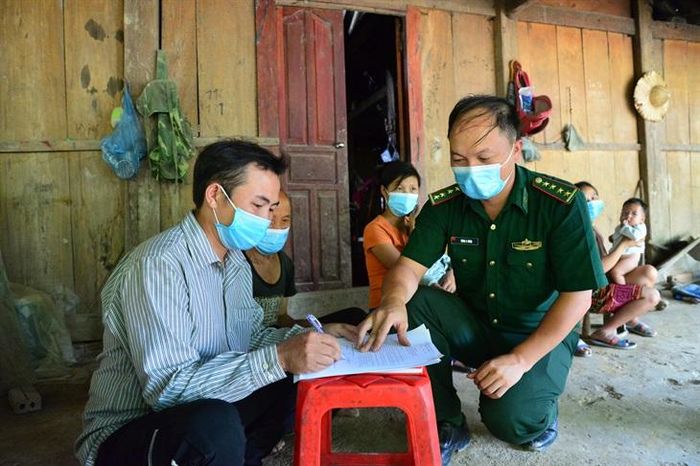 Cán bộ Đồn Biên phòng Na Cô Sa và chính quyền địa phương tổ chức cho người dân ký cam kết không vi phạm pháp luật. Ảnh: Anh Dũng