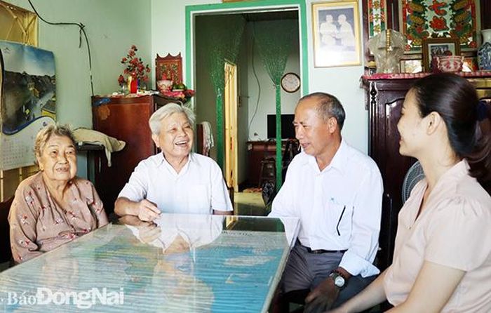 Ông Lê Quyết Chiến và vợ Trần Thị Ức (thứ ba và thứ tư từ phải qua) trò chuyện với cán bộ, đảng viên của Đảng bộ xã An Phước