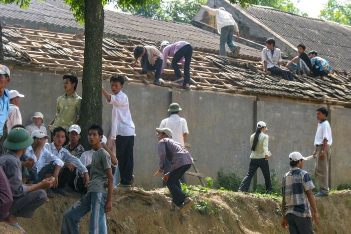 Còn đây là phía sau trường K, hàng chục người trèo lên mái và dỡ ngói một dãy nhà đang sửa để đột nhập vào trường, hòng “đáp giấy”. Ảnh chụp năm 2004