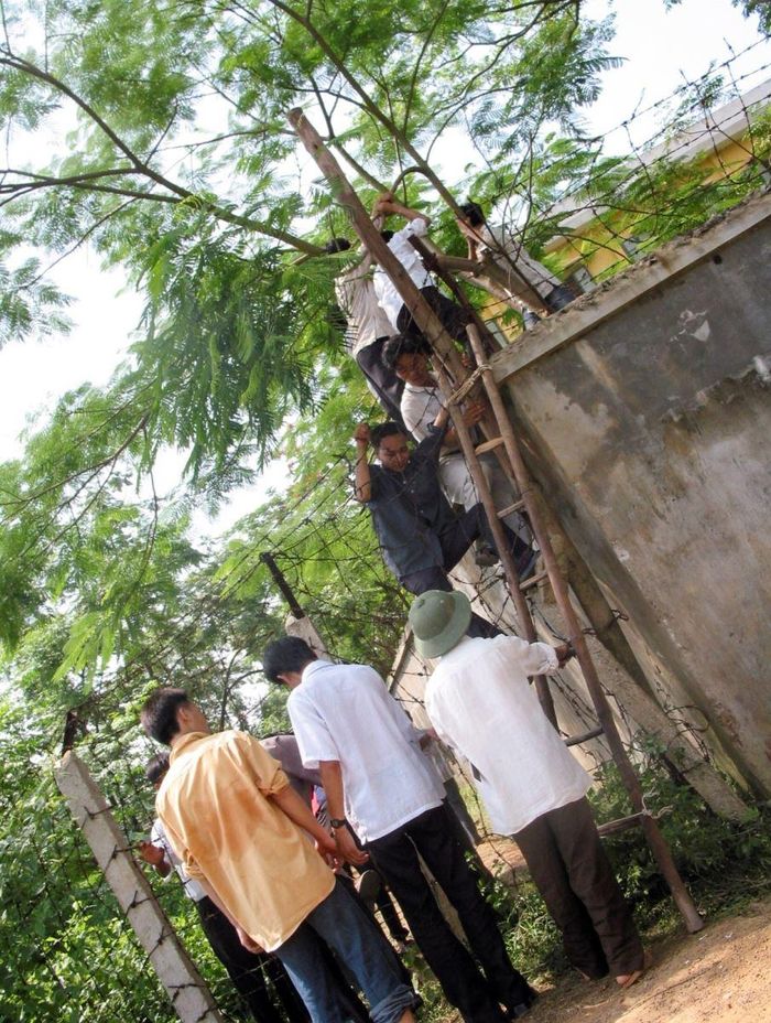Một số chiếc thang được... cho thuê với giá 2.000 đồng một lần trèo vào trường (ảnh này hơi nghiêng vì tác giả phải cho chiếc máy Canon G2 vào một túi nhựa màu đen ngụy trang và thu hình qua một lỗ khoét ở bên sườn). Ảnh chụp năm 2004