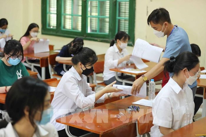 Giám thị tại điểm thi Trường THPT Chu Văn An, quận Tây Hồ phát giấy thi cho thí sinh. Ảnh: Thanh Tùng - TTXVN