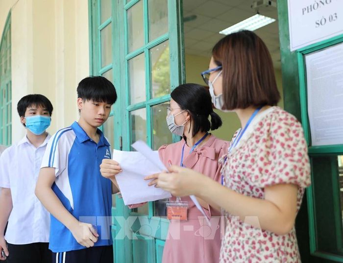 Trước khi vào phòng thi, thí sinh phải bỏ khẩu trang để giám thị kiểm tra phòng khi có gian lận (thi hộ) hoặc phòng trường hợp thí sinh gắn thiết bị thu nhận tín hiệu trong khẩu trang. Ảnh: Thanh Tùng - TTXVN