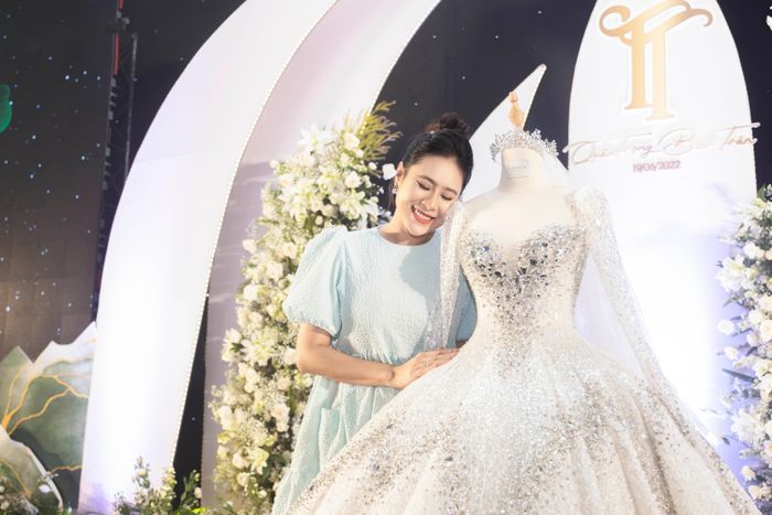  Trong ngày vui, cô dâu chọn lối trang điểm nhẹ nhàng theo tông hồng để thể hiện nét tươi tắn. Kiểu tóc búi cao giúp cô khoe những chi tiết độc đáo trên váy. 