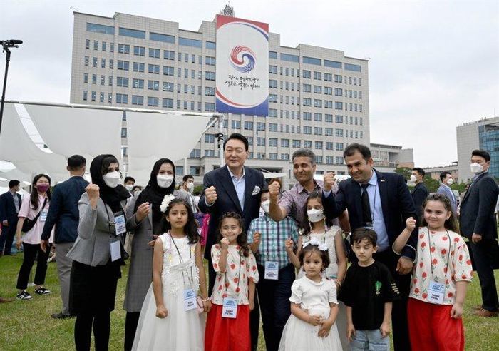 Tổng thống Yoon Suk Yeol chụp hình cùng những người Afghanistan tháo chạy khỏi Afghanistan vào năm ngoái tại sự kiện ngày 19/6. Ảnh: Yonhap.