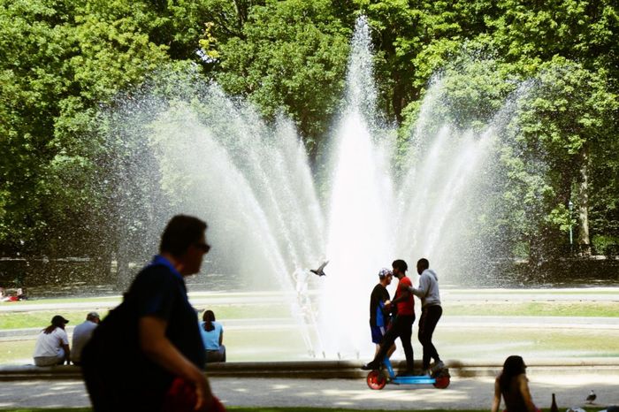 Người dân làm mát bên đài phun nước khi nắng nóng gay gắt ở Brussels, Bỉ. Ảnh: THX/TTXVN