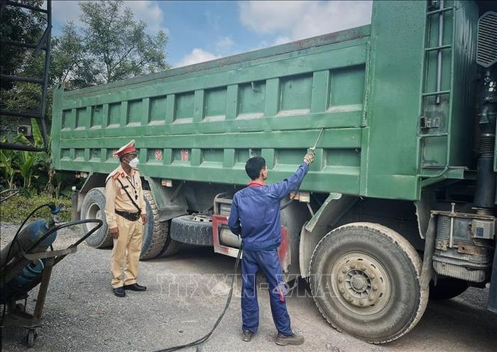 Cắt, tháo phần thùng xe cơi nới thêm. Ảnh: Danh Lam/TTXVN