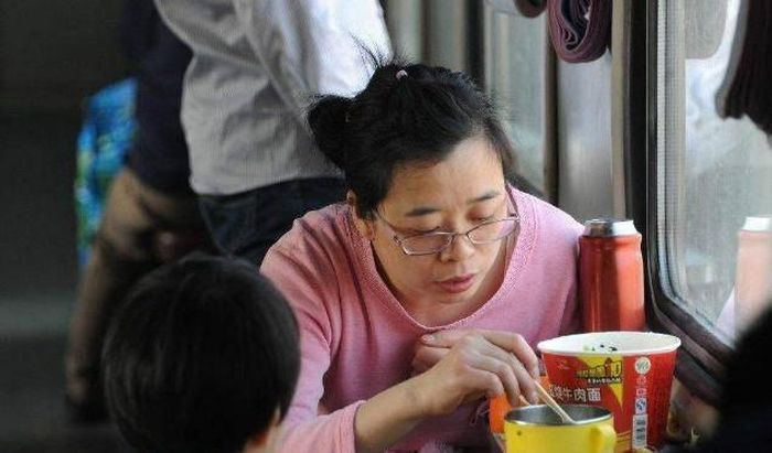 Hai mẹ con ăn mỳ trên tàu hỏa. Ảnh: Sohu