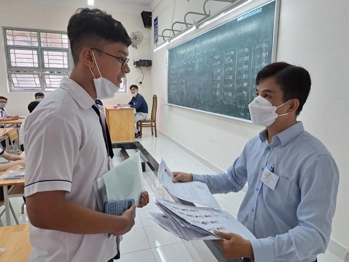 Cán bộ coi thi kiểm tra giấy tờ của thí sinh thí sinh tại điểm thi Trường THPT Phong Phú, huyện Bình Chánh (TP Hồ Chí Minh).