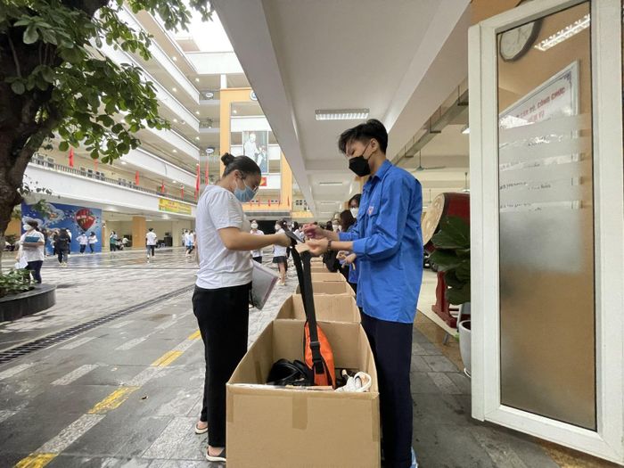 Lực lượng tình nguyện viên trông đồ cho các thí sinh để vào trường thi.