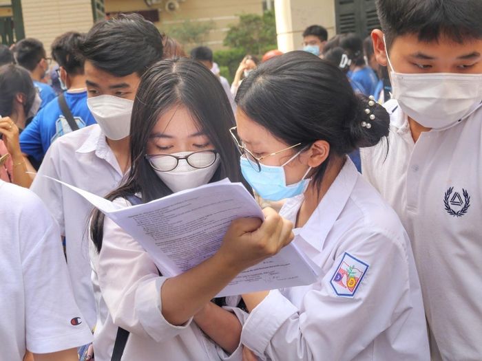 Thí sinh trao đổi bài làm môn Ngoại ngữ tại điểm thi Trường THPT Kim Liên, quận Đống Đa. Ảnh: Tuấn Đức - TTXVN