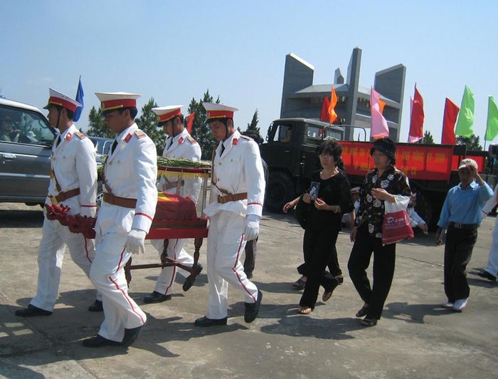 Chị Vũ Lưu Liên cầm di ảnh liệt sĩ Trần Minh Tiến trong lễ an táng anh tại Nghĩa trang Đường 9, ngày 9/5/2008. Nguồn: Nhà văn Đặng Vương Hưng. 