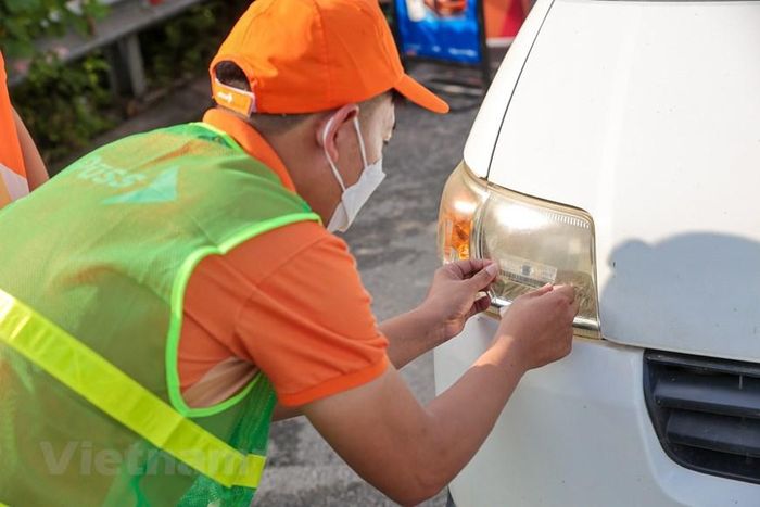 Đại diện Công ty cổ phần Giao thông số Việt Nam (VDTC) cho hay sẽ bố trí nhân viên hướng dẫn lái xe từ đầu tuyến để hạn chế xe chưa dùng ETC vào cao tốc. Tài xế muốn sử dụng dịch vụ sẽ được hướng dẫn dán thẻ, nạp tiền ngay tại trạm. (Ảnh: Minh Sơn/Vietnam+)