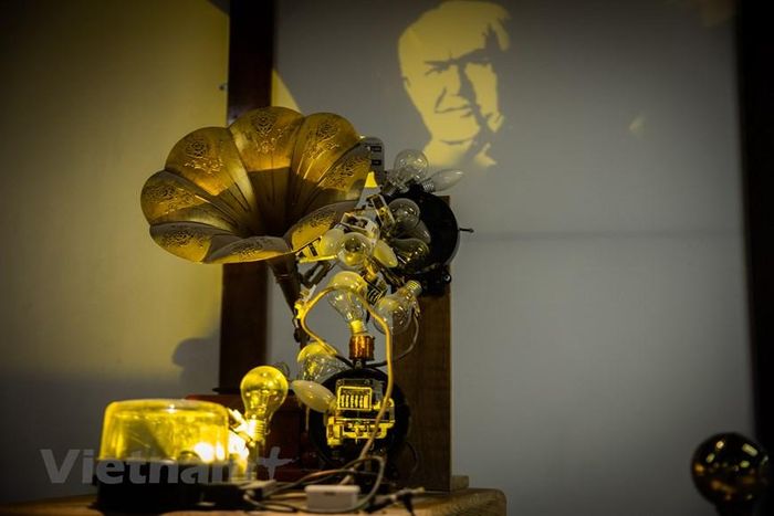 Tác giả sử dụng những phát minh của Edison như bóng đèn sợi đốt, máy hát đĩa quay để làm phần vật thể phía trước. Bức chân dung của nhà bác học Edison sẽ hiện ra khi ánh sáng chiếu vào các phát minh của ông. (Ảnh: Hoài Nam/Vietnam+)
