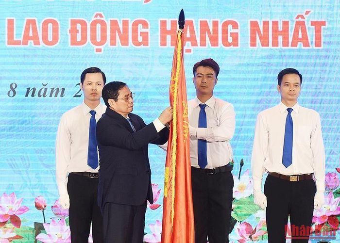 Thủ tướng Phạm Minh Chính gắn Huân chương Lao động hạng Nhất lên cờ truyền thống của Bộ Tài nguyên và Môi trường.