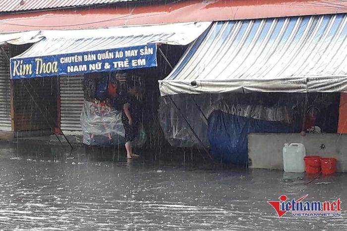 Tiểu thương chợ Thủ Đức tìm cách ngăn nước 'tấn công', kê hàng hóa lên cao để tránh bị hư hại