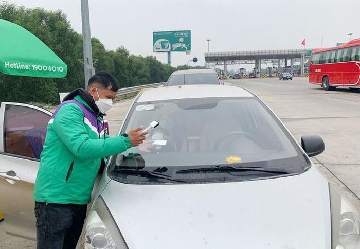 Nhân viên VETC dán thẻ cho khách hàng