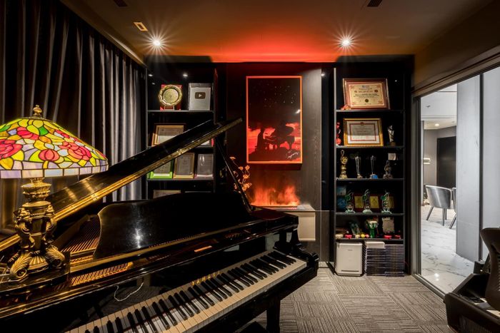 Phòng làm việc trưng bày nhiều nhạc cụ, điểm nhấn là cây grand piano Yamaha đắt đỏ.