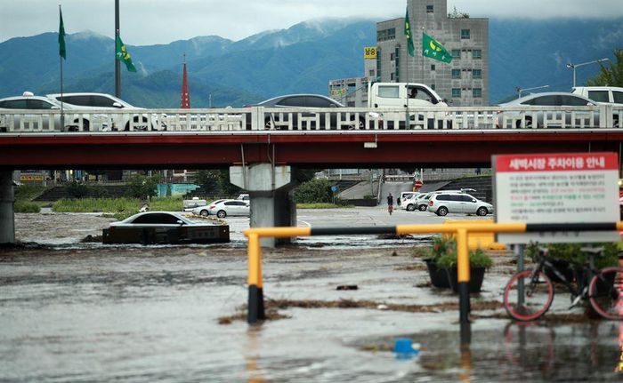 Một chiếc ô tô đậu trên bờ sông của suối Wonju ở tỉnh Gangwon bị ngập sau trận mưa xối xả hơn 200 mm trong khu vực. Ảnh: Yonhap.