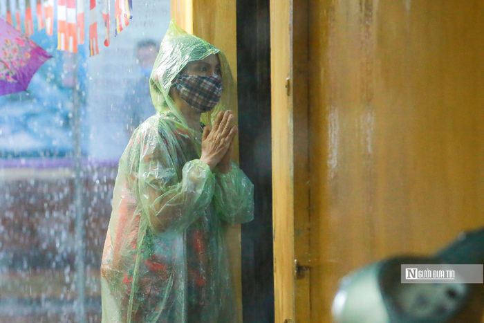 Do diện tích hẹp, những người đến sau vẫn mặc y nguyên bộ quần áo mưa để làm lễ phía bên ngoài.