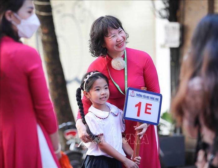 Giáo viên trường Tiểu học Thăng Long đón học sinh lớp 1 tới trường.