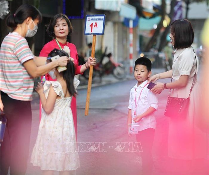 Giáo viên trường Tiểu học Thăng Long đón học sinh lớp 1 tới trường.