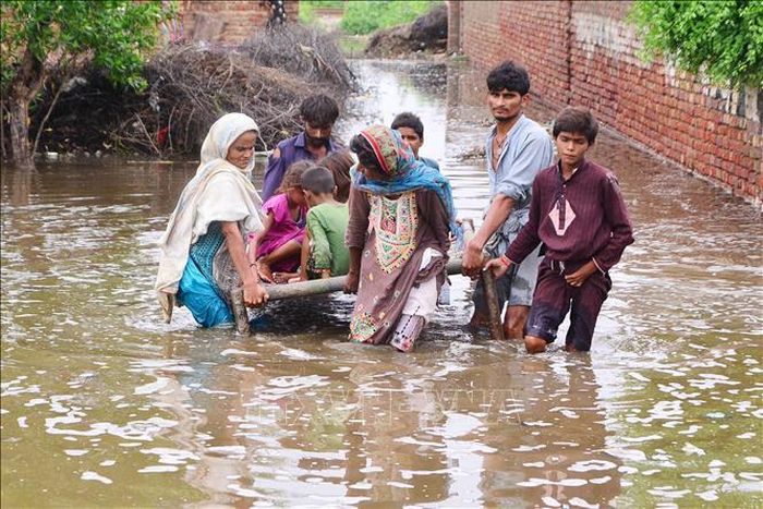 Người dân sơ tán khỏi vùng ngập lụt tại huyện Tando Allahyar, tỉnh Sindh, Pakistan, ngày 25/8/2022. Ảnh: THX/TTXVN