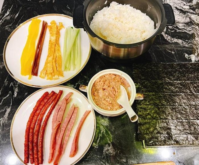 Cơm viên rất dễ làmm chỉ cần 1 tô cơm dẻo nấu chín, lá rong biển, chút mè rang, thêm ít cà rốt và dầu mè là có thể hoàn thành trong vòng "một nốt nhạc". Nguyên liệu làm cơm cuộn cũng dễ kiếm không kém, thêm xúc xích, trứng tráng mỏng, dưa leo và thêm "topping" tùy thích.
