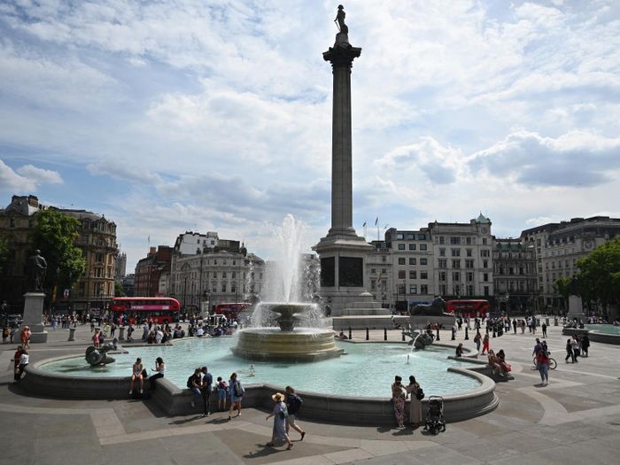 Người dân tránh nóng bên đài phun nước tại Quảng trường Trafalgar ở thủ đô London, Anh. Ảnh: AFP/ TTXVN