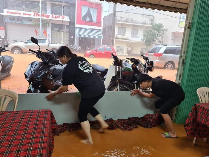 Người dân dùng tấm ván chắn nước tràn vào nhà dân. 