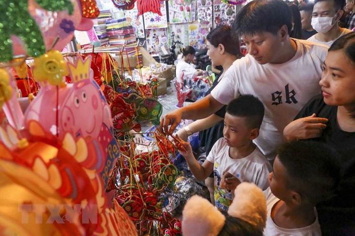 Các em nhỏ lựa chọn những món đồ chơi truyền thống. (Ảnh: Tuấn Đức/TTXVN)