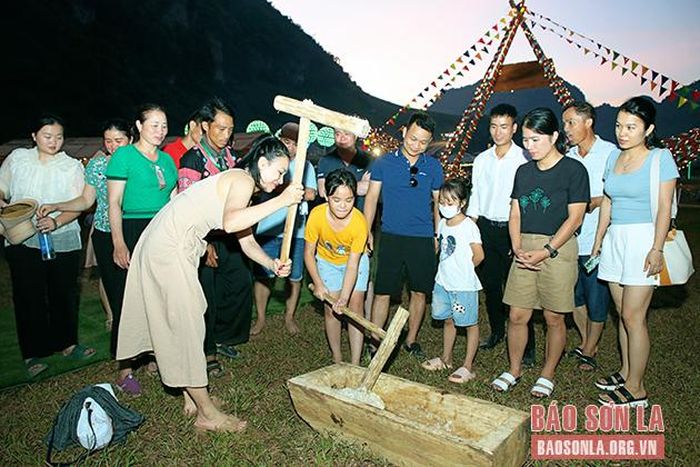 Du khách trải nghiệm giã bánh dày tại phiên chợ.