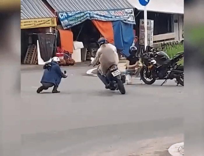 Trong lúc chàng trai đang ở tư thế ngồi xổm để quay video, tên cướp đã đi xe máy đến, nhanh tay giật chiếc điện thoại trên tay chàng trai rồi rời đi.