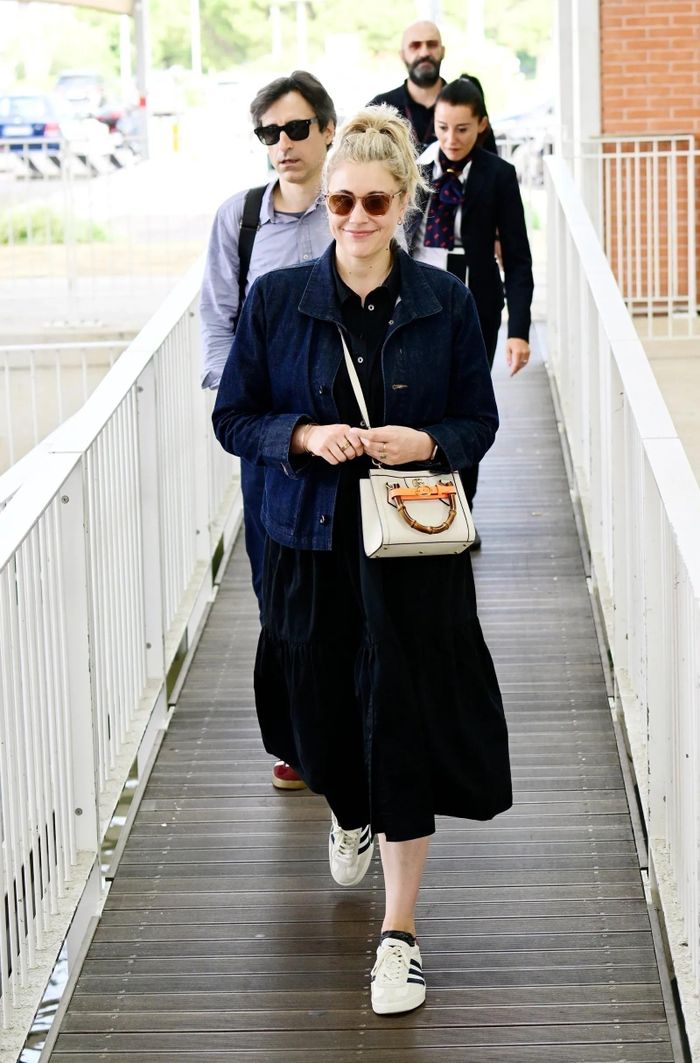  Tại sân bay, phụ kiện của Gucci được nhiều nghệ sĩ sử dụng. Greta Gerwig phối đồ với mẫu túi xách tông trắng từ thương hiệu Italy. Cô diện váy liền cùng áo khoác denim và sneakers tông trắng. Ảnh: Backgrid. 