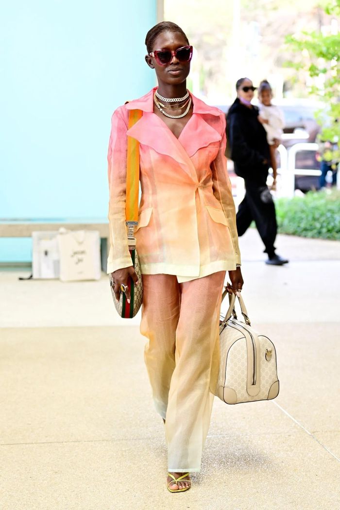  Jodie Turner-Smith sải bước tại sân bay trong bộ đồ hai mảnh. Thiết kế có màu vàng, hồng với phần cổ cách điệu. Cô xách theo 2 mẫu túi xách từ Gucci và sử dụng kính râm bản to để set đồ thêm phần thời thượng. Ảnh: Backgrid. 