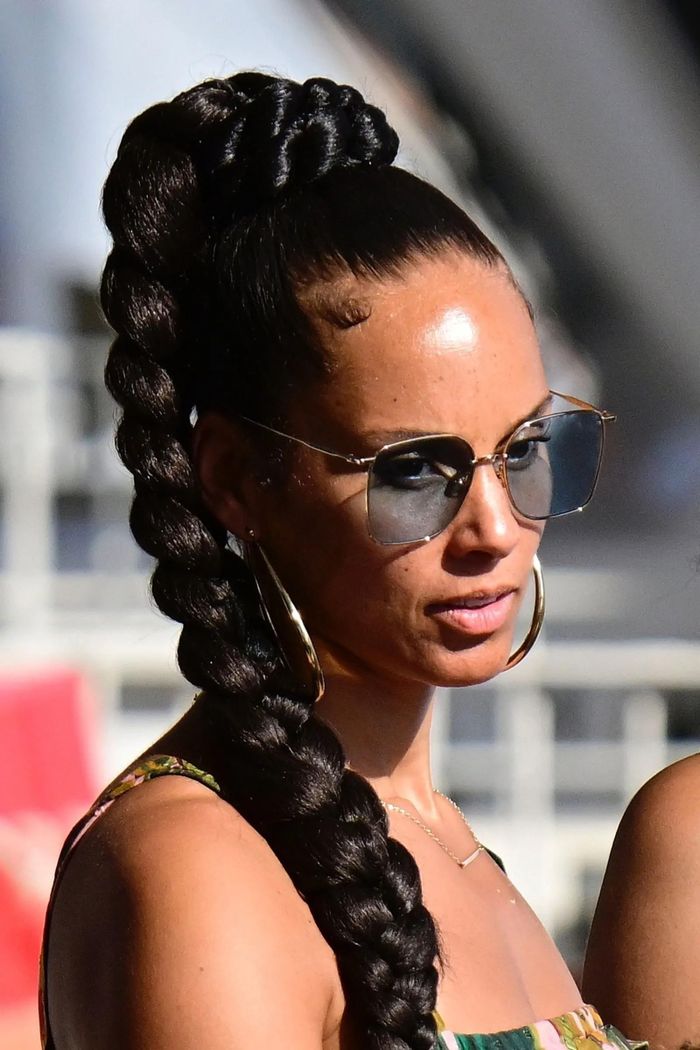 Alicia Keys tết tóc và buộc đuôi ngựa. Cô diện mẫu váy hoa dáng xòe. Để bộ đồ nhìn sang trọng, nữ ca sĩ dùng thêm loạt phụ kiện như vòng cổ, khuyên tai tông vàng. Ảnh: Daily Mail, Vogue.