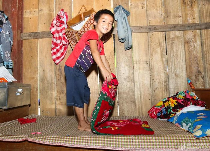 Tự dọn dẹp góc giường của mình trong nhà bán trú của trường, Vi Dương Hiếu (8 tuổi, học sinh lớp 3B) cho biết: “Đây là lần đầu tiên em xa bố mẹ, buổi ngày đi học và vui chơi với bạn bè thì không sao, nhưng buổi tối em rất nhớ nhà, nhớ bố mẹ”. Ảnh: Đình Tuân