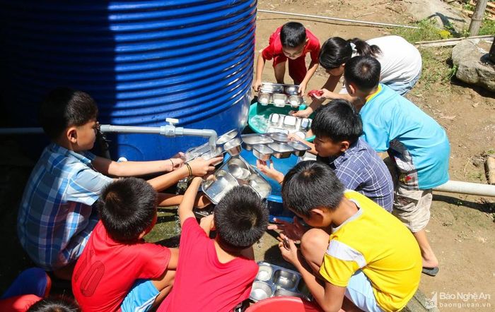Sau khi ăn cơm xong, các em tự mang theo khay cơm ra bể nước để rửa. Tuy còn khá nhỏ, nhưng các em rửa rất thuần thục và sạch sẽ. Ảnh: Đình Tuân
