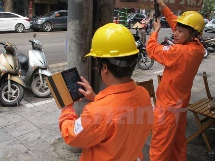 Ứng dụng công nghệ trong việc ghi chỉ số công tơ điện của khách hàng. (Ảnh: Đức Duy/Vietnam+)