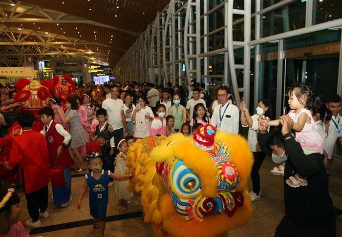 Du khách nước ngoài thích thú chụp ảnh các đoàn múa lân rước đèn trung thu tại "Đêm hội trăng rằm" ở Đà Nẵng. Ảnh: Trần Lê Lâm - TTXVN