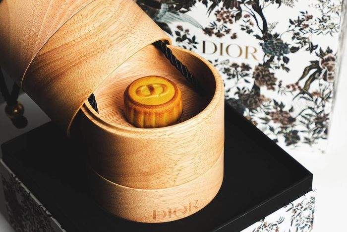 Trên thực tế, đây là thiết kế hộp bánh Trung thu năm nay của Dior. Hãng chọn hộp đựng chất liệu gỗ với kiểu dáng hình trụ tròn trịa, sang trọng. Những chiếc bánh Trung thu in logo thương hiệu như thế này thường được dùng để tặng khách hàng, đối tác thân thiết. Ảnh: Alex Hau.