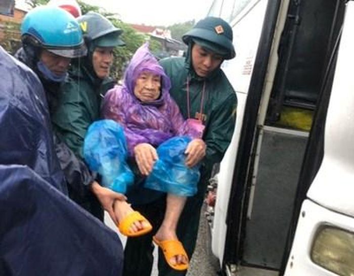 LLVT tỉnh Quảng Ngãi giúp người tuổi cao, sức yếu lên xe ô tô để về nơi tránh bão. 