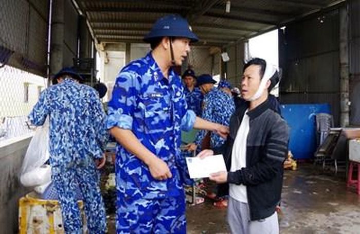 Cán bộ Vùng Cảnh sát biển 2 thăm hỏi, hỗ trợ tiền giúp gia đình anh Võ Văn Tính ở xã Triệu An (Triệu Phong, Quảng Trị) mua vật liệu sửa nhà. 