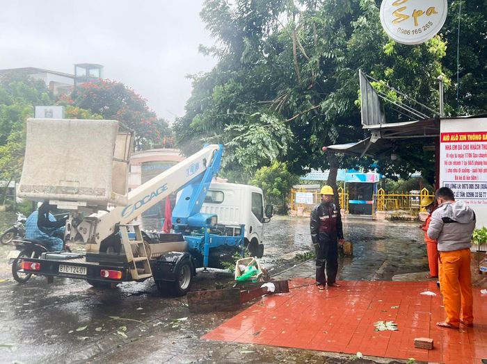 Công nhân nhanh chóng cắt tỉa cây xanh bị gió quật ngã đổ, đảm bảo lưu thông. Ảnh: Đinh Yến