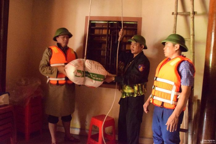 Gia đình ông Nguyễn Văn Hiền ở xóm Phú Lập, xã Thanh Xuân chỉ có 2 ông bà già, nên đoàn hỗ trợ gia đình vận chuyển đồ đạc đến vị trí cao ráo, tránh bị ngập nước. Ảnh: Xuân Hoàng